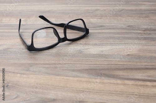 Black frame eyeglasses isolated on the wooden table