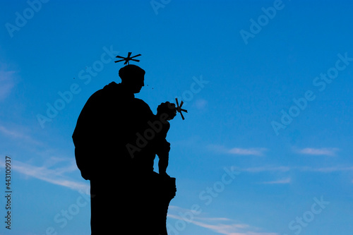 Outline of Statue of Saint Anthony of Padua on Charles Bridge on blue sky background