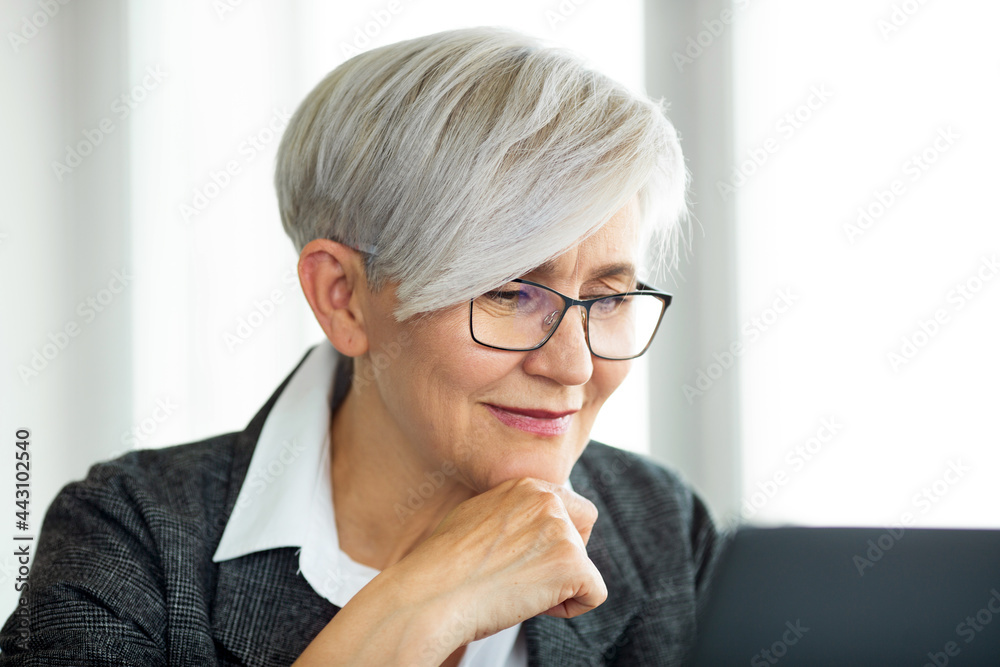 portrait of an adult businesswoman at work with a laptop wearing glasses portrait of an adult businesswoman at work with a laptop wearing glasses