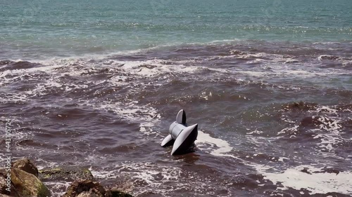 inflatable killer whale abandoned in the open sea, contaminated and dirty water