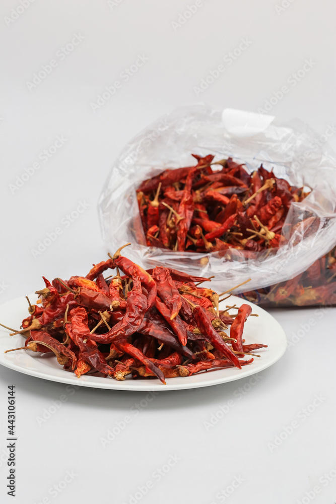 Fototapeta premium red dried chili hot spicy in white dish blurred background plastic bag chili and copy space