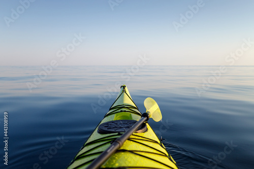 Yellow kayak with a paddle close-up in focus. The background of the sea is blurred. Active water sports. photo