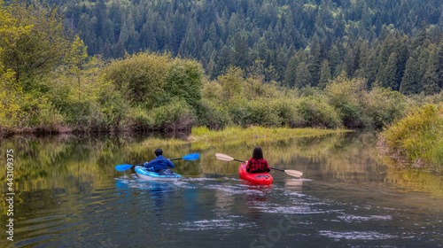 Adventure Friends Kayaking in Kayak surrounded by Canadian Mountain Landscape. Taken in Widgeon Valley, Pitt Meadows, Vancouver, British Columbia, Canada.