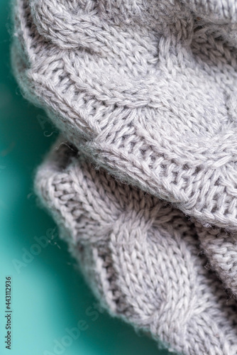 Fragment of a gray knitted plaid close-up. Vertical 