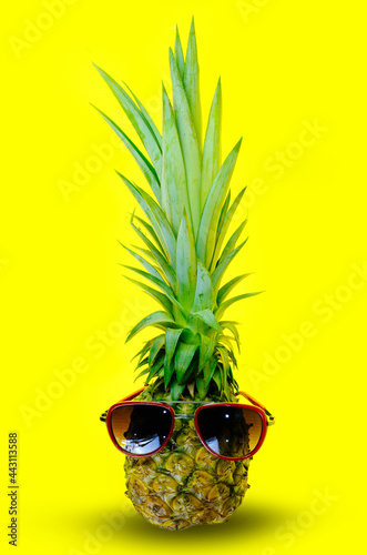 Pineapple wearing red sunglasses on isolated yellow background