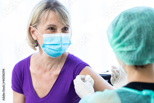 Women wearing masks getting vaccinated. Mature woman mask who approves covid-19 vaccination at hospital. Female doctor immunizes elderly patients against the virus. Concept of coronavirus, vaccination