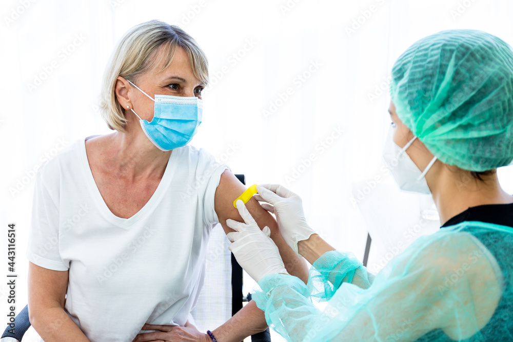 woman wearing mask getting vaccinated concept of coronavirus vaccination mask grown woman approved for covid-19 vaccination at the hospital. Female doctor immunizes against virus with medical plaster. woman wearing mask getting vaccinated concept of coronavirus vaccination mask grown woman approved for covid-19 vaccination at the hospital. Female doctor immunizes against virus with medical plaster.