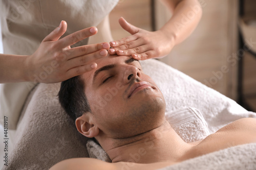 Man receiving facial massage in beauty salon photo