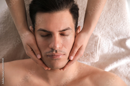 Man receiving facial massage in beauty salon  top view