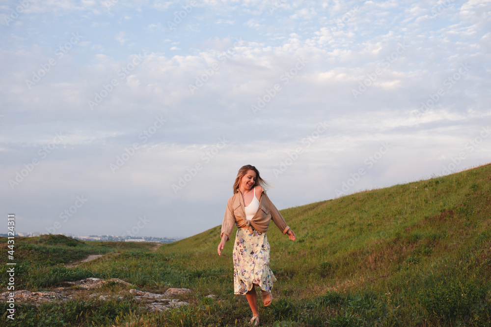Happy young girl 22-24 year old having fun running in green grass lawn landscape outdoors. Care free woman at countryside. Summer vacation season. Happy young girl 22-24 year old having fun running in green grass lawn landscape outdoors. Care free woman at countryside. Summer vacation season.