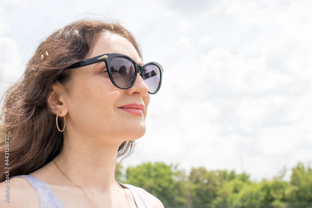 Beautiful brunette woman smiling in sunglasses with place for text. Glasses advertising, affirmations and achieving dreams, making wishes.