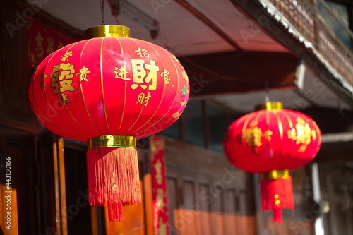 Colorful style red lanterns hanging decoration in traditional Asian street setting.