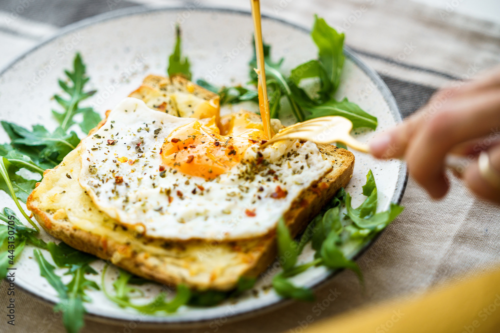 Anonymous person eating toast with eggs and cheese