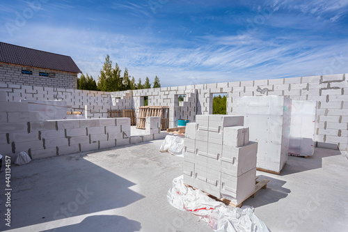house construction. raising the walls with aerated concrete blocks, several pallets of bricks
