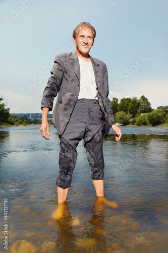 Manager in grey suit became crazy of hot weather and cooling in river photo