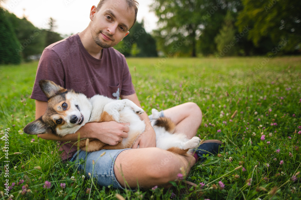 Sable welsh corgi pembroke and his owner, happy and relaxed during a walk in a park