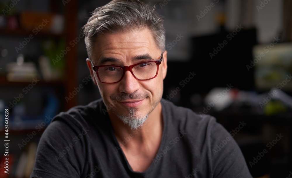 Portrait of older man with gray hair at home sitting in armchair in cosy living room. Portrait of older man with gray hair at home sitting in armchair in cosy living room.