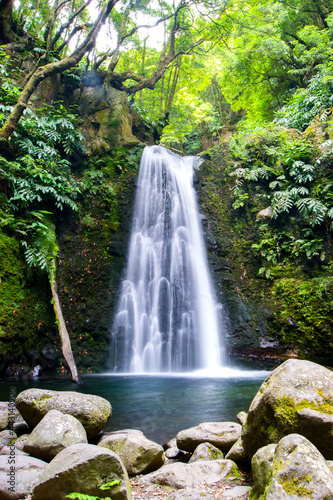 Beautiful secret wild waterfall in a green jungle environment in Azores islands.