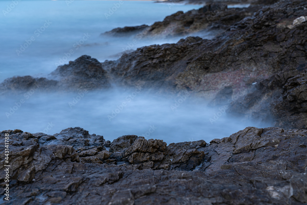 A photo of the blurry sea waves on the rocky shore of the Adriatic Sea