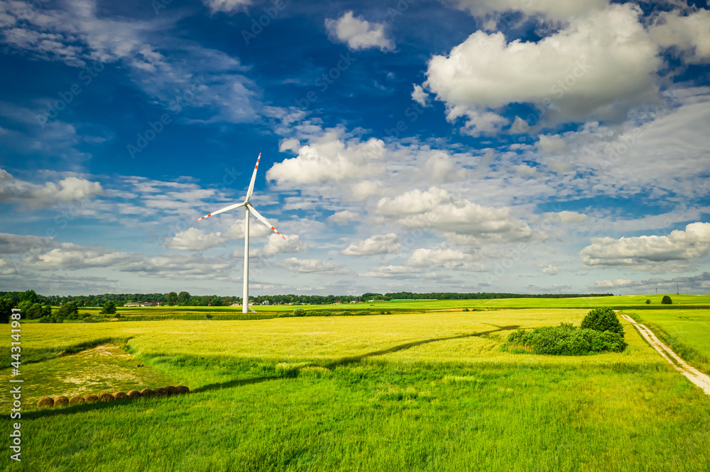 White wind turbine on field. Agriculture in countryside in Poland. White wind turbine on field. Agriculture in countryside in Poland.