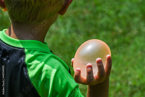 Child holding water balloon for water balloon fight