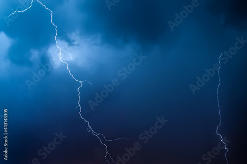 Lightning in the night sky. Thunderstorm over the city. Stormy clouds and rainy weather.