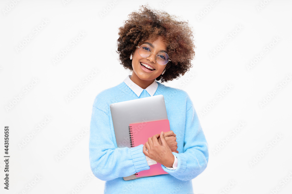 Laughing funny african american teen girl, online course or high school student holding laptop and pink notebook, isolated on gray background Laughing funny african american teen girl, online course or high school student holding laptop and pink notebook, isolated on gray background