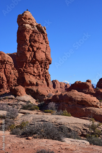 a dramatically-eroded tower n a sunny day in arches national park, near moab, utah 