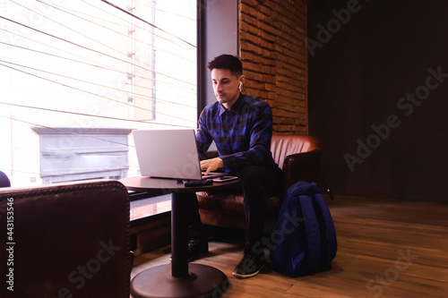 Young handsome businessman working with his laptop in a coffee shop.