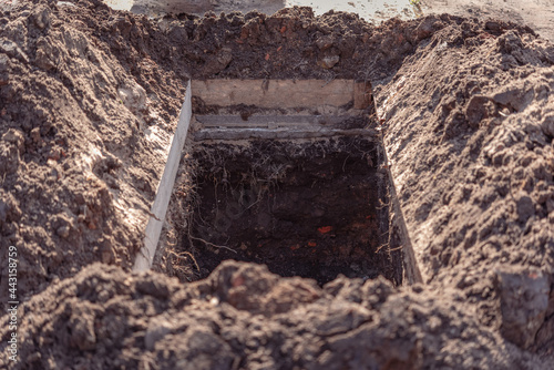 Obraz na płótnie Freshly dug grave pit at cemetery, a close-up.