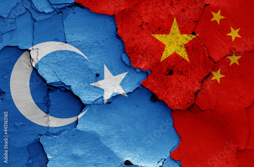 flags of East Turkestan and China painted on cracked wall photo