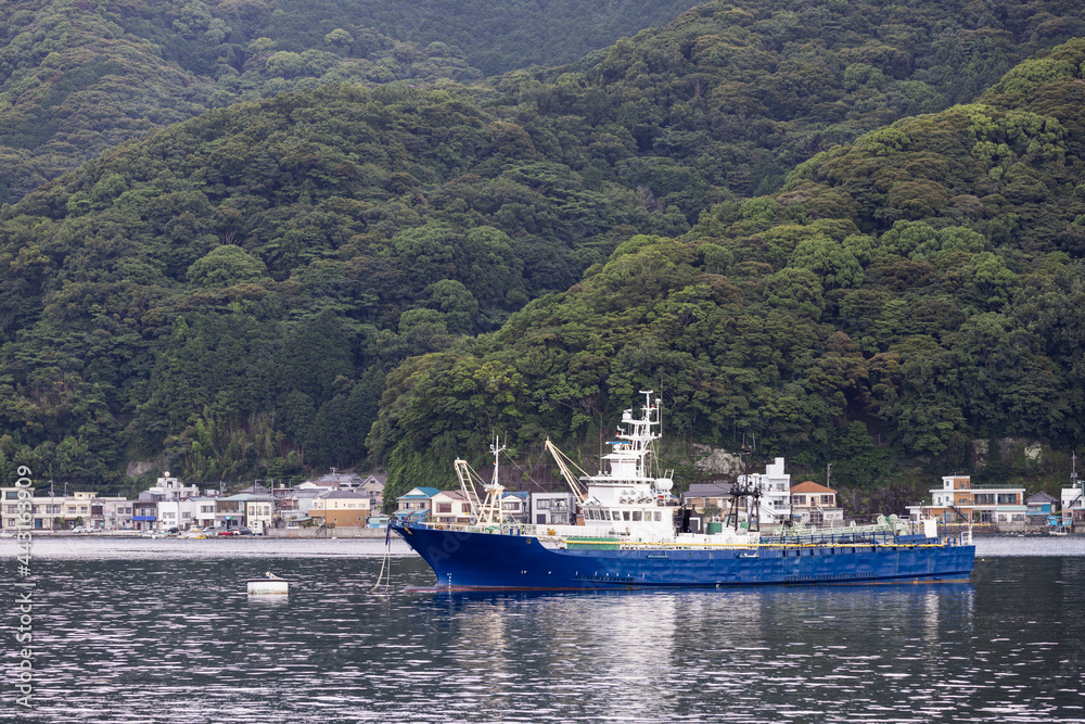 山に囲まれた小さな湾にブイ係留する船舶 山に囲まれた小さな湾にブイ係留する船舶