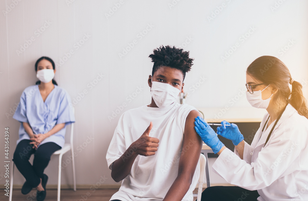 Obraz premium African boy wearing face mask getting vaccinated during coronavirus or covid-19 pandemic at hospital,Vaccination concept