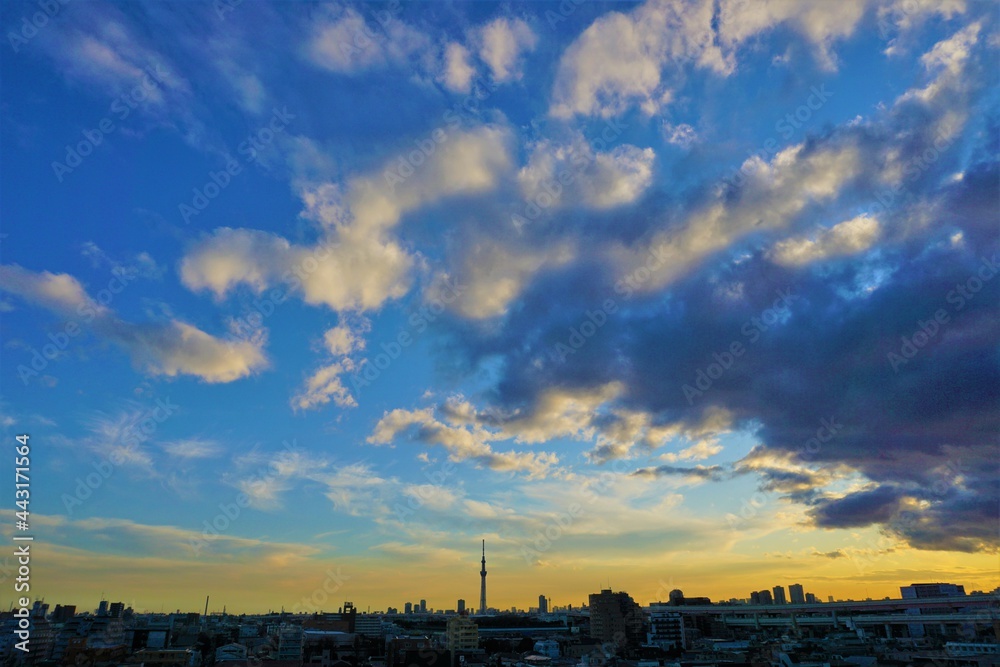 青から黄色への美しい空のグラデーションの映える東京の空とビルやタワー等の建造物立ち並ぶ風景
