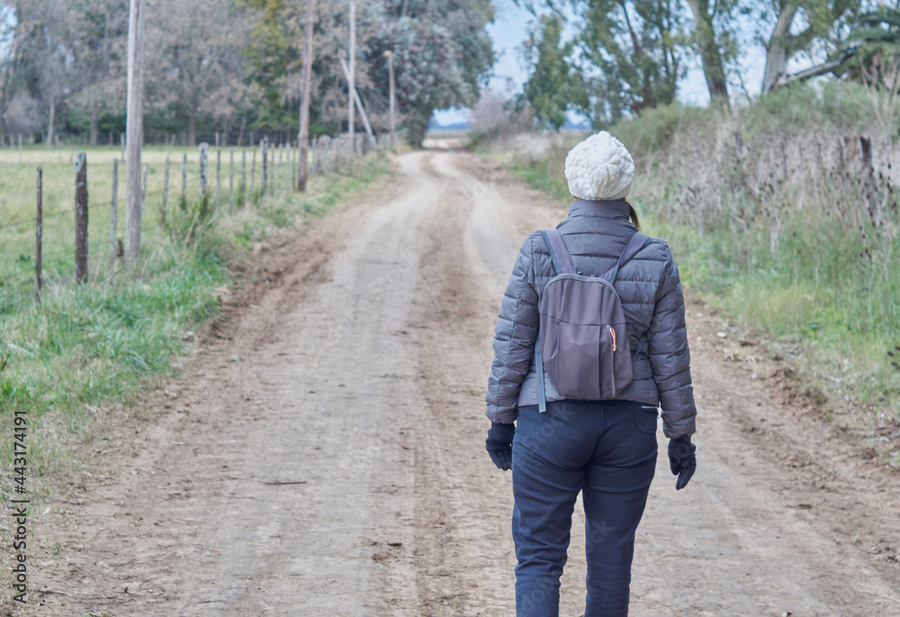 Mujer explorando un camino rural