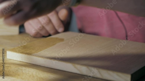 applying wood stain on a wooden oak board with a sponge. application of wood impregnation and wood oil. woodworking concept