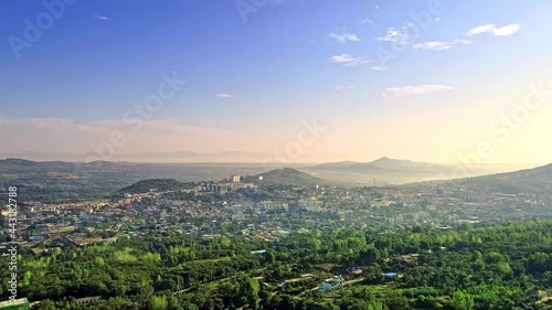Aerial panorama of Henan, China at sunrise, cities between mountains and forest photo