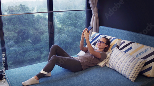 Photography Young beautiful caucasian woman lying in the bed and making selfie in the morning
