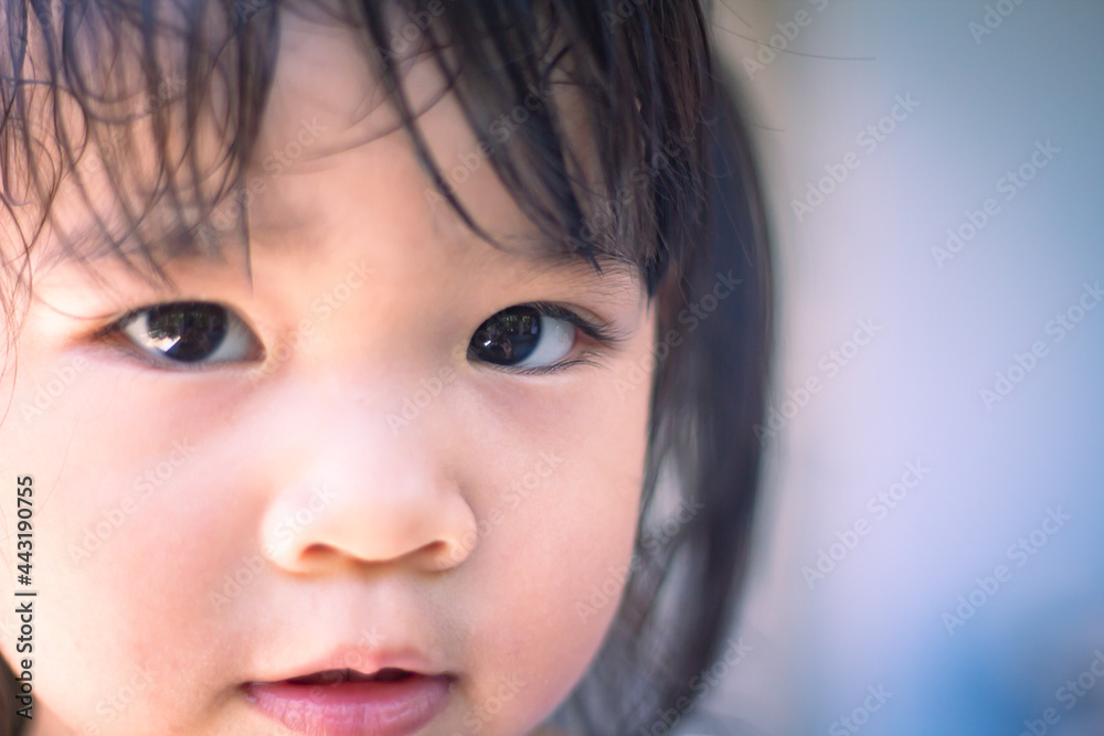 A headshot portrait select focus at left eye of a cheerful baby Asian woman, a cute toddler little girl with adorable bangs hair, a child wearing a blue sweater smiling and looking to the camera. A headshot portrait select focus at left eye of a cheerful baby Asian woman, a cute toddler little girl with adorable bangs hair, a child wearing a blue sweater smiling and looking to the camera.