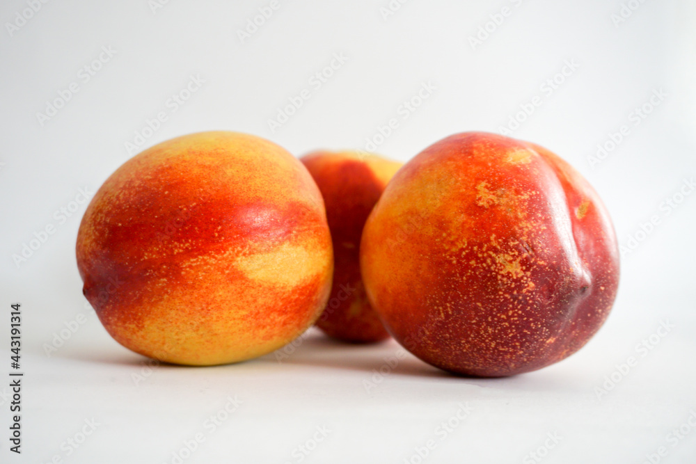 Side view of three nectarines on white background Side view of three nectarines on white background