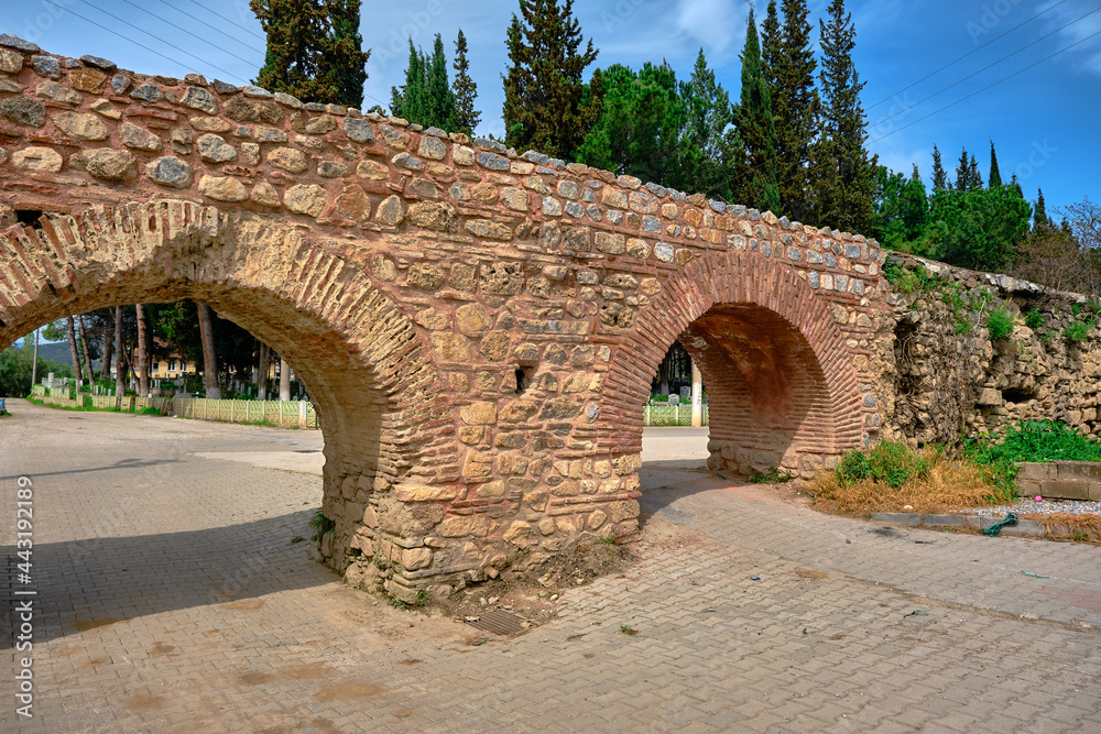 Ancient city walls and water ways in iznik made of red bricks wall covered by and grass with blue sky background established by byzantine empire.