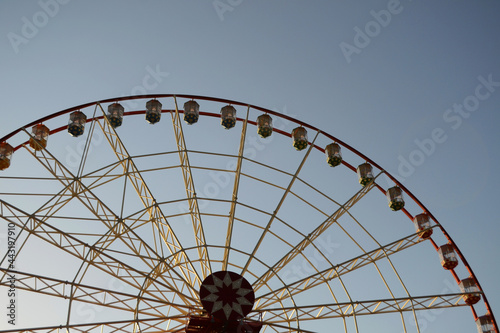 Round Ferris wheel on a background of blue sky.