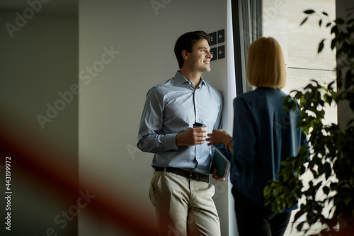 Happy businessman enjoying on coffee break with female colleague and looking through the window. photo