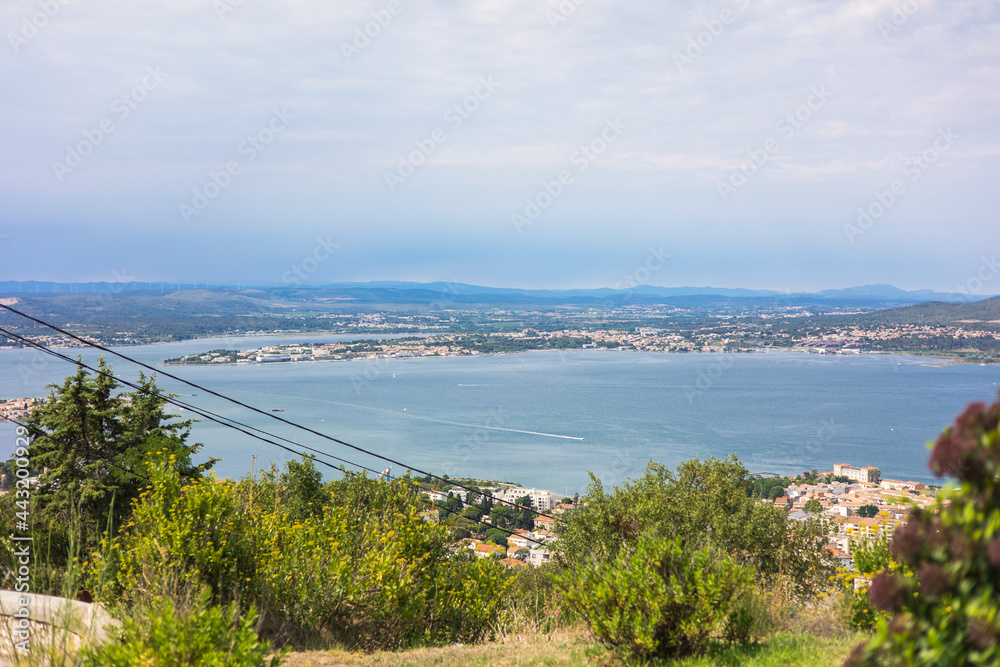 Vue sur la ville de Sète, entre l'étang de Thau et la mer Méditerranée, depuis le Mont Saint-Clair (Occitanie, France) Vue sur la ville de Sète, entre l'étang de Thau et la mer Méditerranée, depuis le Mont Saint-Clair (Occitanie, France)