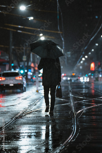 Man Walking Past Department Store Window in City at Night 