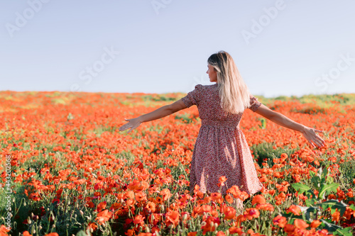 Photos Blonde woman in a poppy field at sunset