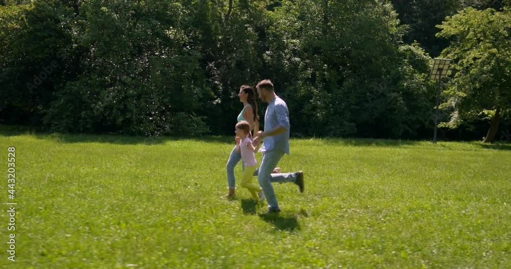 Happy young family with cute little daughter having fun in park on a sunny day Happy young family with cute little daughter having fun in park on a sunny day