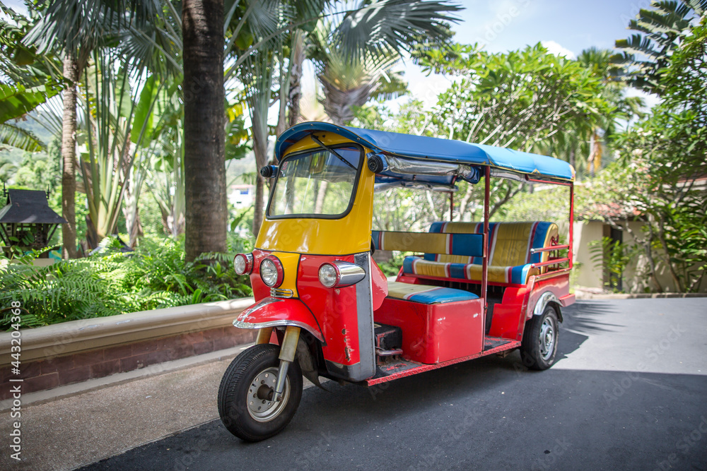 Tuk Tuk in Red Yellow and Blue waiting for passengers