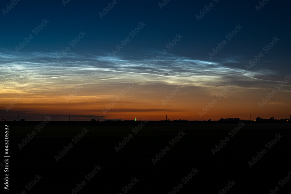 Majestic display of noctilucent clouds in the northern sky on a late June evening