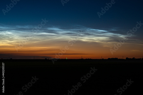 Majestic display of noctilucent clouds in the northern sky on a late June evening